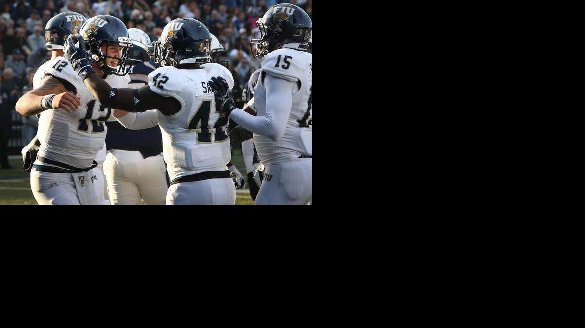 
FIU quarterback Alex McGough, left, is congratulated by Anthon Samuel after McGough's two yard touchdown run in first quarter action at S.B. Ballard Stadium in Norfolk on Nov. 8, 2014.
