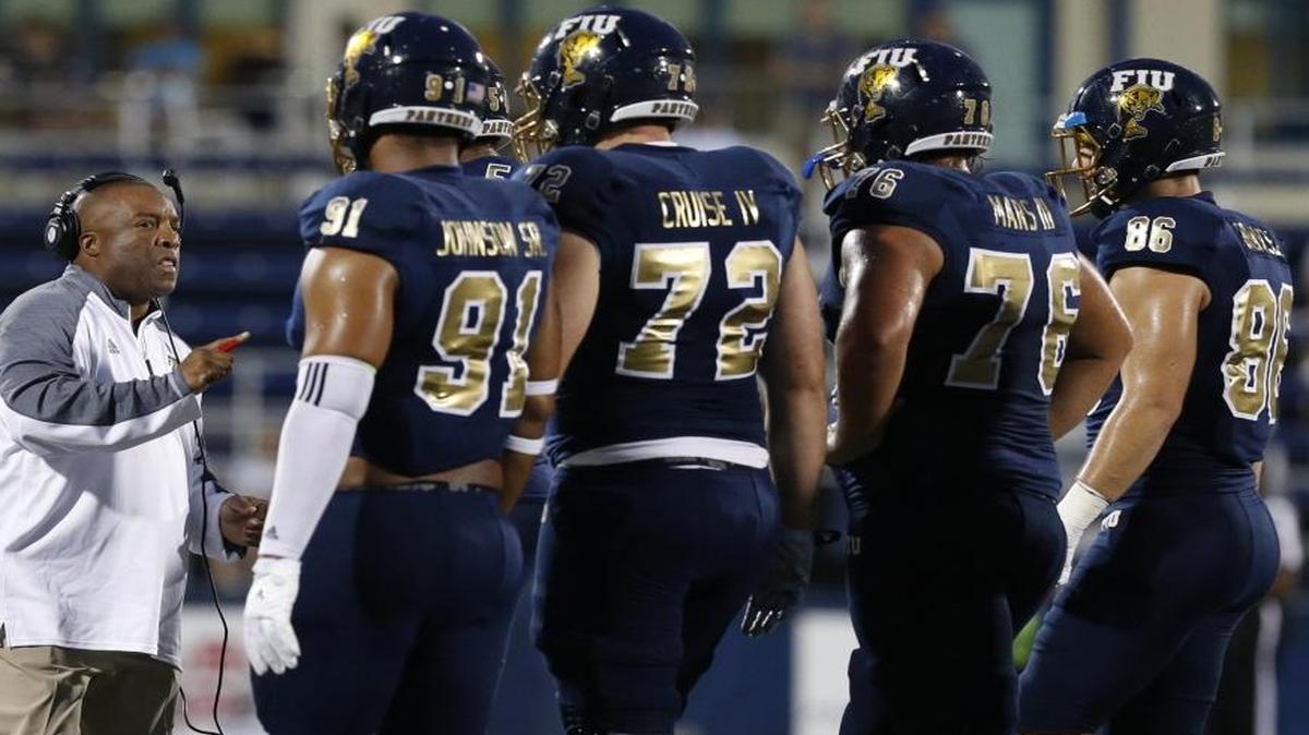 FIU's Ron Cooper, Interim Head Coach, on the field with players as Florida International University hosts Florida Atlantic University at Ocean Bank Field on Saturday, October 1, 2016.