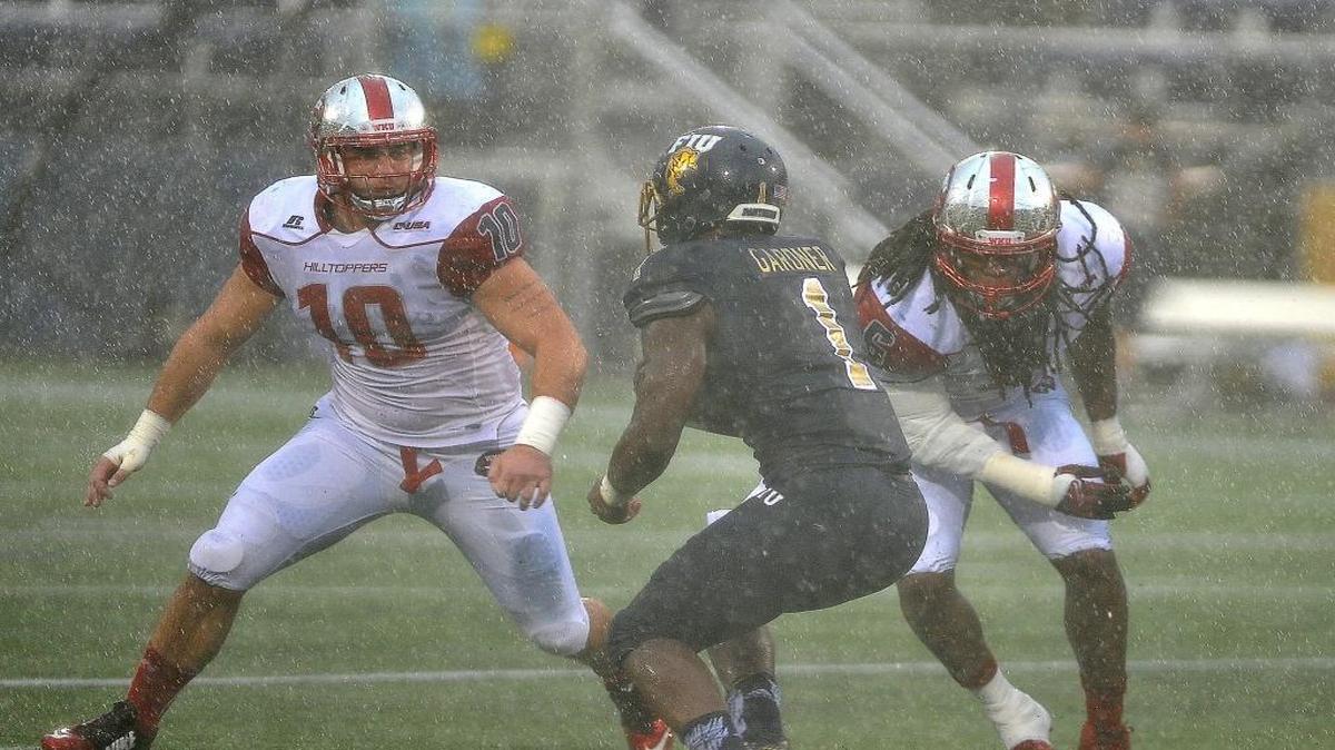 Florida International University running back Alex Gardner (1) tries to evade WKU linebackers Nick Holt (10) and T.J. McCollum as he carries the ball during a college football game Saturday Nov. 21, 2015 in Miami against Western Kentucky University. WKU beat FIU 63-7