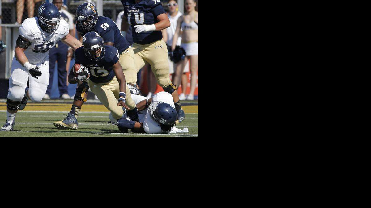 
FIU quarterback Alex McGough can’t escape the grasp of linebacker Alex Lyons.
