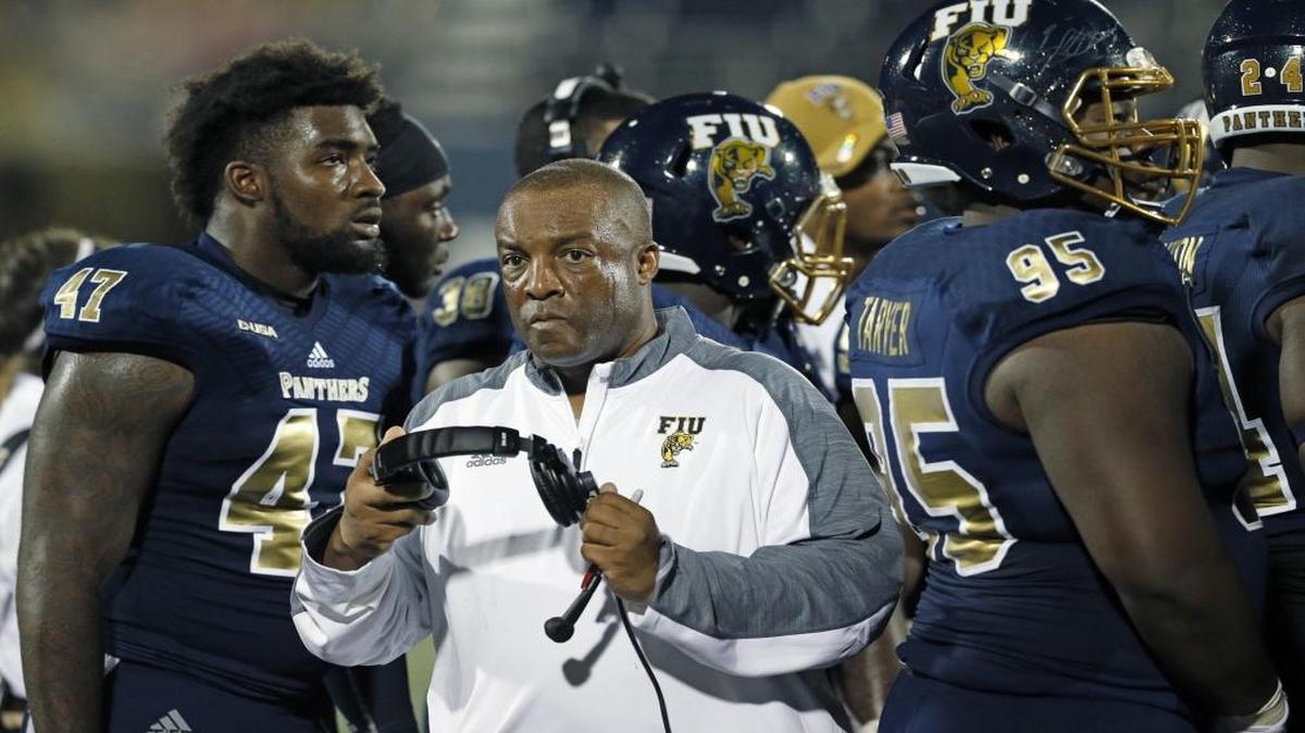 FIU's Ron Cooper, Interim Head Coach, on the field with players as Florida International University hosts Florida Atlantic University at Ocean Bank Field on Saturday, October 1, 2016.