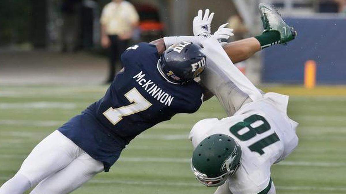 
FIU Jeremiah McKinnon (7) brings down Wagner ballcarrier Tyler Loftus (18) on Saturday, Sept. 6, 2014 in Miami.
