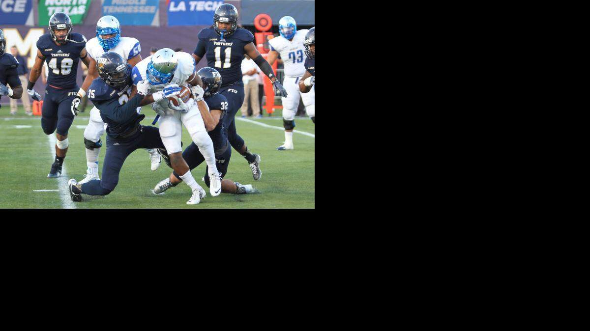 
Davison Colimon, Line Backer for Florida International University, looks to bring down running back, Shane Tucker, during Saturday's game against MTSU.

