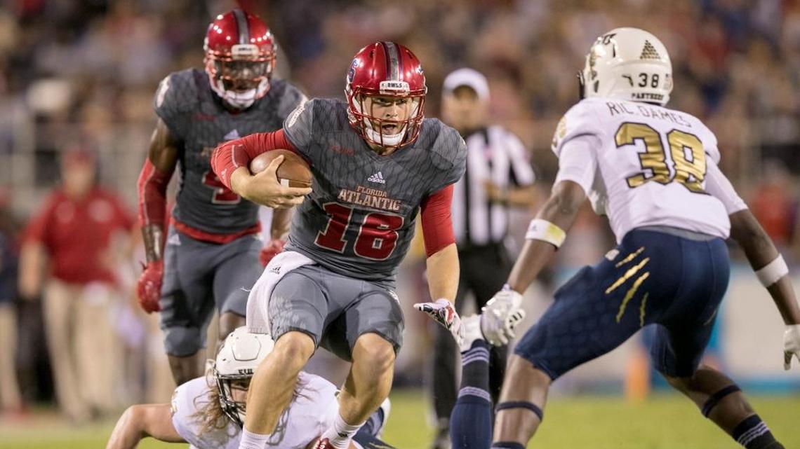 Florida Atlantic Owls quarterback Jason Driskel (16) runs for a first down after escaping a tackle attempted FIU defensive end Newton Salisbury (97) as defensive back Richard Dames (38) moves in to make the stop in the first quarter at FAU Stadium in Boca Raton, Florida on November 19, 2017.