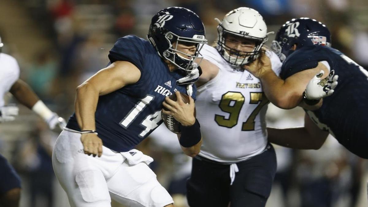 Jackson Tyner #14 of the Rice Owls is pressured by Newton Salisbury #97 of the FIU Golden Panthers in the fourth quarter at Rice Stadium on Sept. 23, 2017 in Houston, Texas.