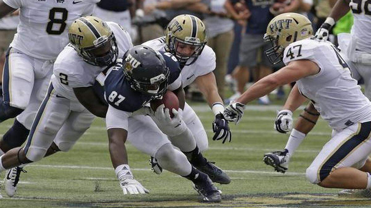 
FIU Panthers Jonnu Smith (87) tries to escape a tackle by Pittsburgh defenders during their football game at FIU Stadium in Miami on Sept. 13, 2014.
