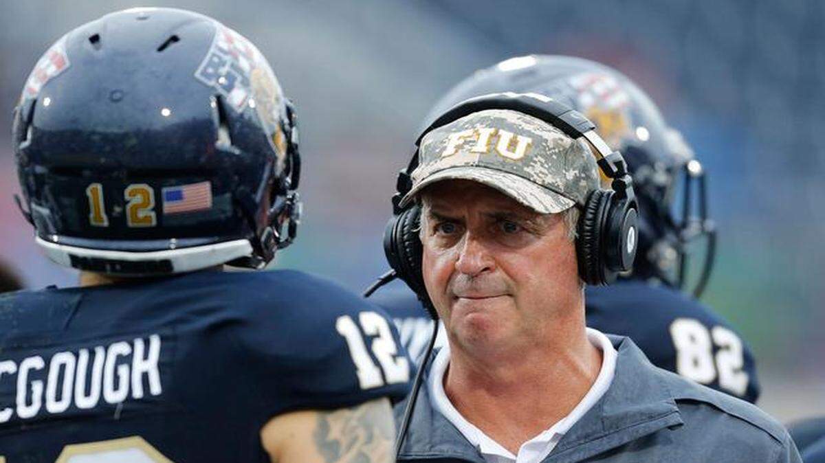 
Head coach Ron Turner talks to Alex McGough # 12 of the Florida International Panthers after he threw an interception against the Louisville Cardinals on September 20, 2014 at FIU Stadium in Miami, Florida.
