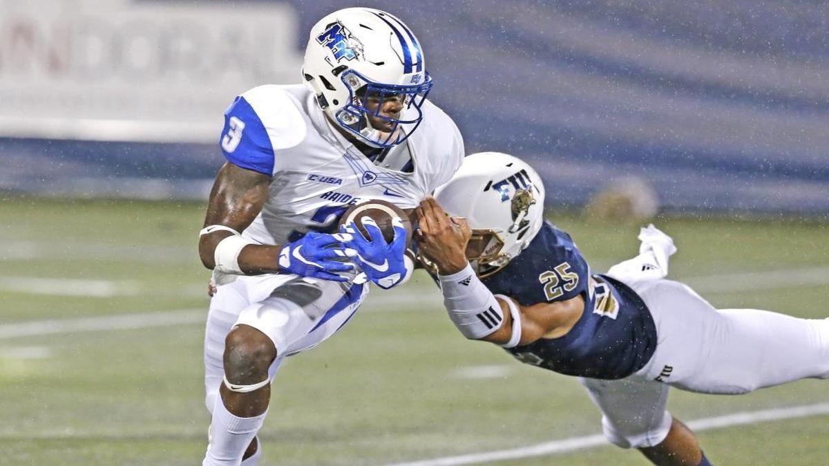 Middle Tennessee wide receiver Richie James runs with the ball as FIU safety Isaiah Hill tries to make the tackle in the first half on Saturday, October 29, 2016.