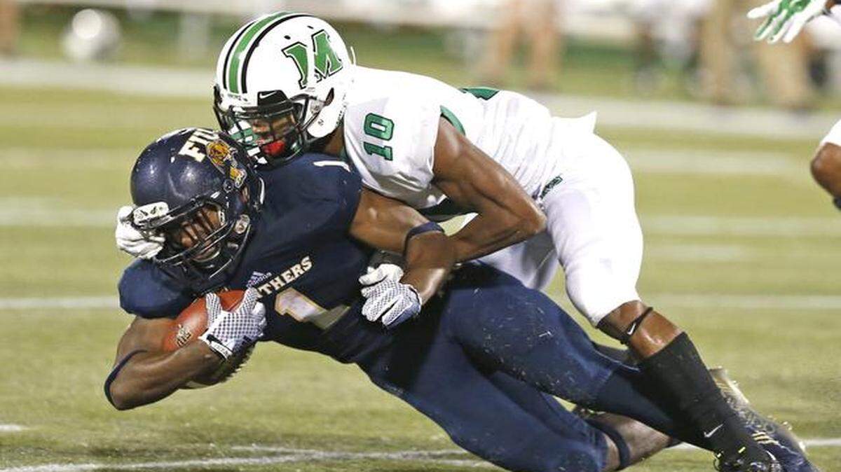 
FIU Panthers running back Alex Gardner (1) as taken down by defensive back Corey Tindal (10) as both are injured on the play in the fourth quarter as FIU hosts Marshall at Ocean Bank Stadium in Miami on Saturday, October 18, 2014.
