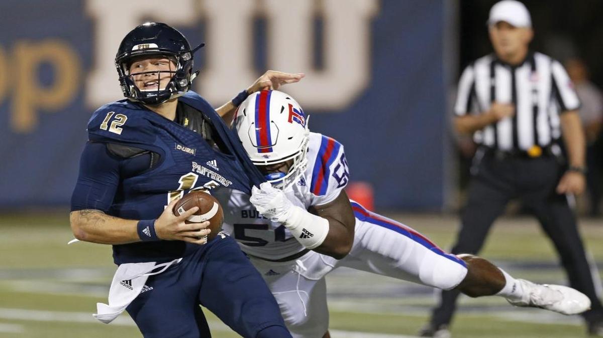 FIU Panthers quarterback Alex McGough (12) is chased by Louisiana Tech Bulldogs defensive end Deldrick Canty (50) in the first quarter as the FIU Panthers host the Louisiana Tech Bulldogs at Ocean Bank Field at FIU Stadium on Oct. 22, 2016.