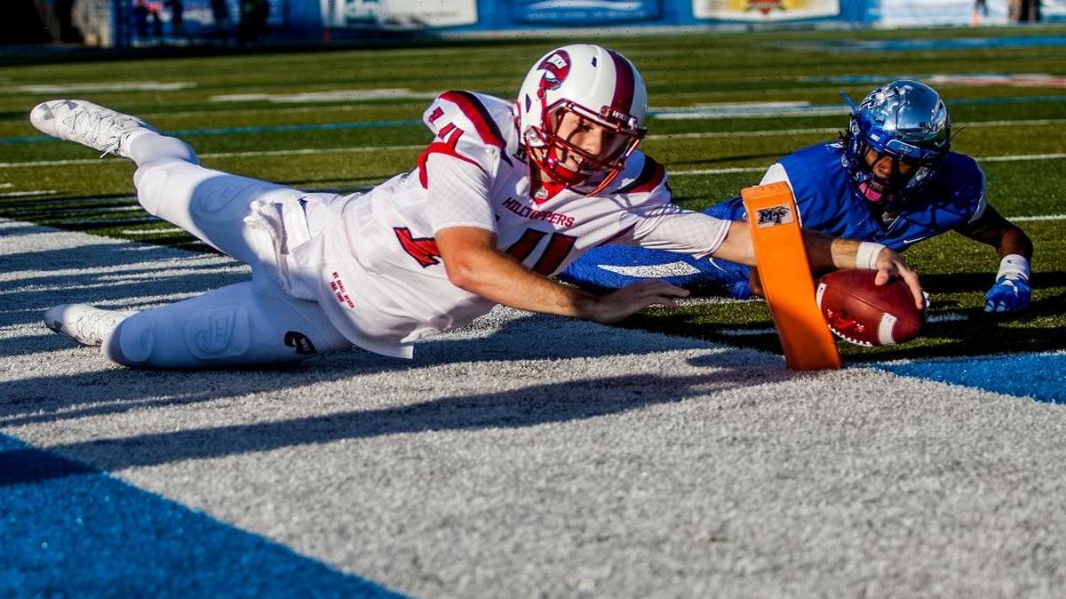 Western Kentucky quarterback Mike White (14) reaches for the pylon while pursued by Middle Tennessee cornerback Michael Minter (6) during an NCAA college football game in Murfreesboro, Tenn., Sat., Oct. 15, 2016. The play was first called a touchdown, but was overturned upon review. Western Kentucky won 44-43 in double overtime.
