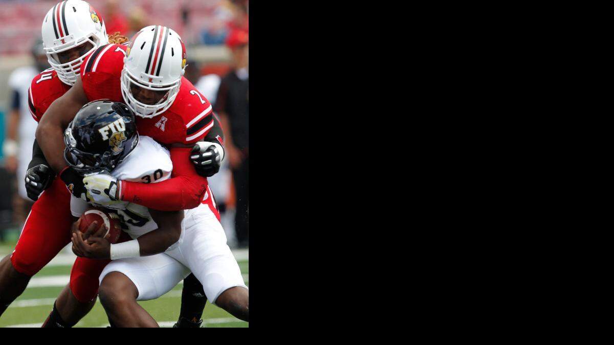 
Preston Brown #2 and Lorenzo Mauldin #94 of Louisville tackle Silas Spearman #30 of the FIU at Papa John's Cardinal Stadium on Sept. 21, 2013 in Louisville, Kentucky. 

