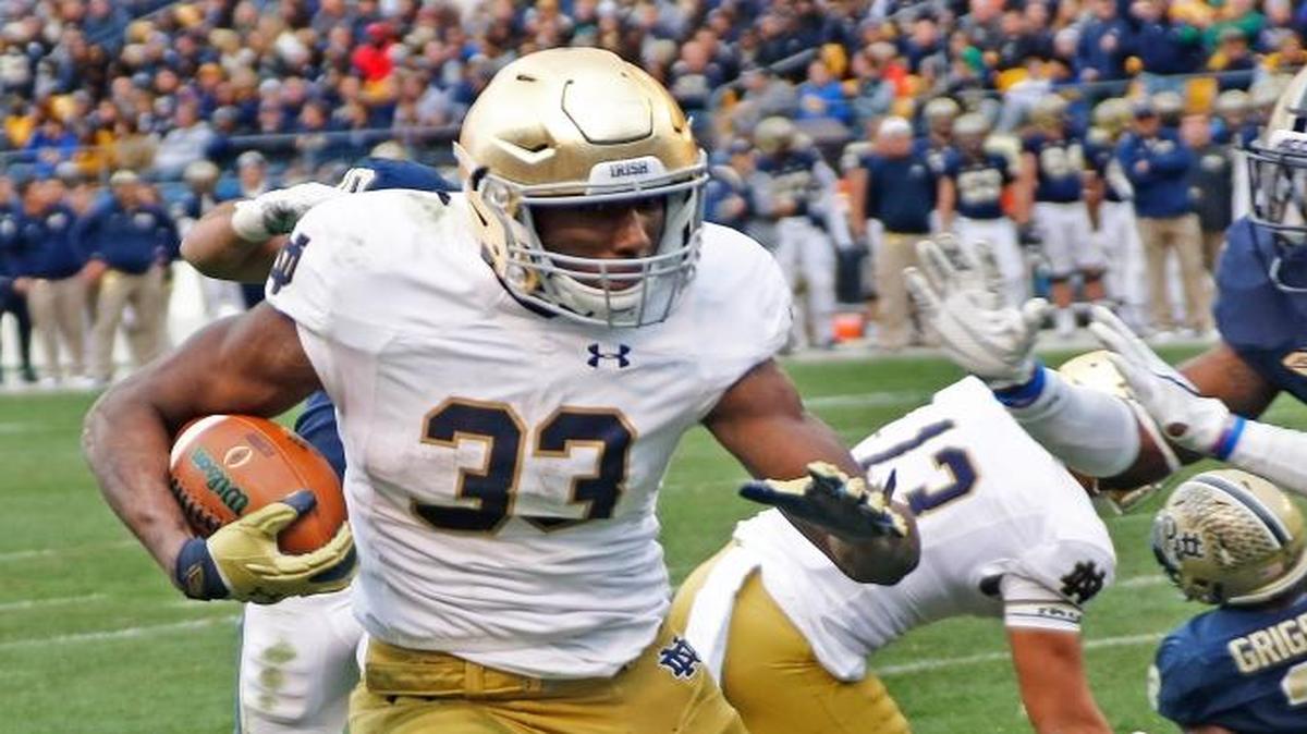 Notre Dame running back Josh Adams (33) runs past Pittsburgh defensive back Jordan Whitehead (9) for a touchdown in the third quarter Saturday, Nov. 7, 2015 in Pittsburgh. Notre Dame won 42-30.
