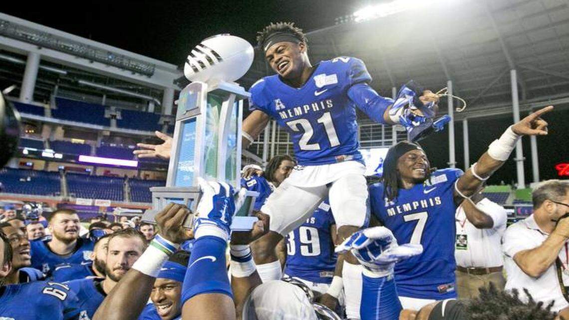 
The good and the bad: Memphis defensive back Bobby McCain celebrates wih teammates after defeating Brigham Young University in double overtime of the Miami Beach Bowl. Below, the teams were involved in a postgame fight that left some players bloodied and bruised.
