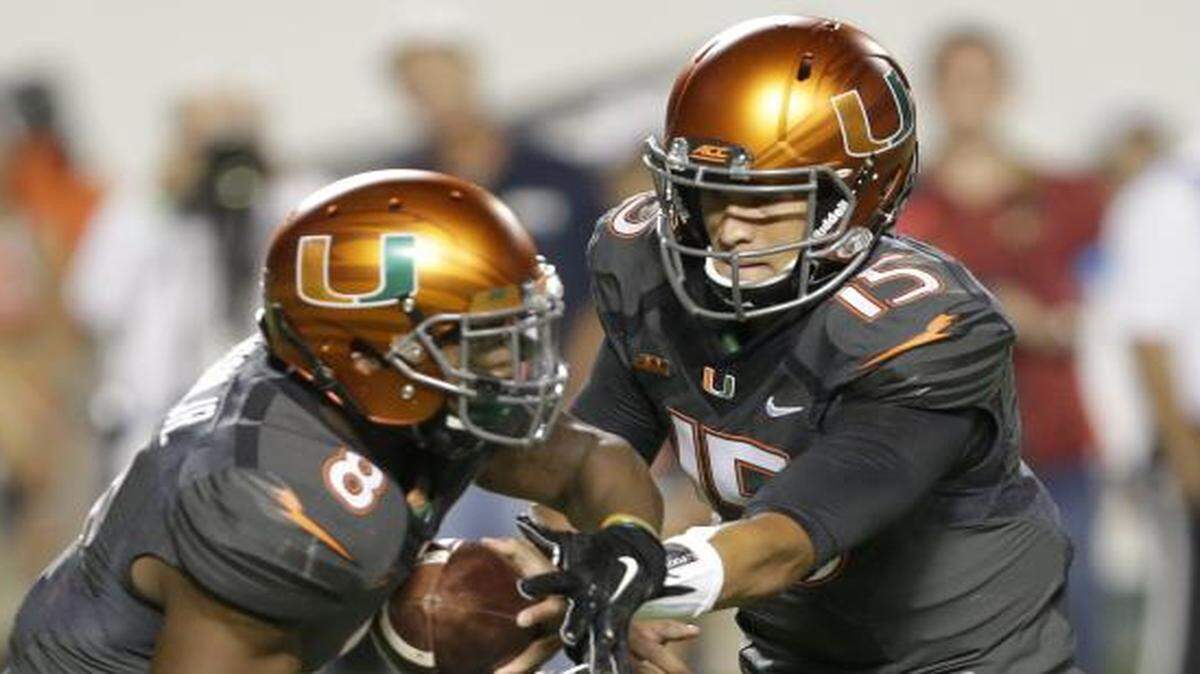 
Miami quarterback Brad Kaaya, right, hands off to running back Duke Johnson (8) against Florida State, Saturday, Nov. 15, 2014 in Miami Gardens, Fla.
