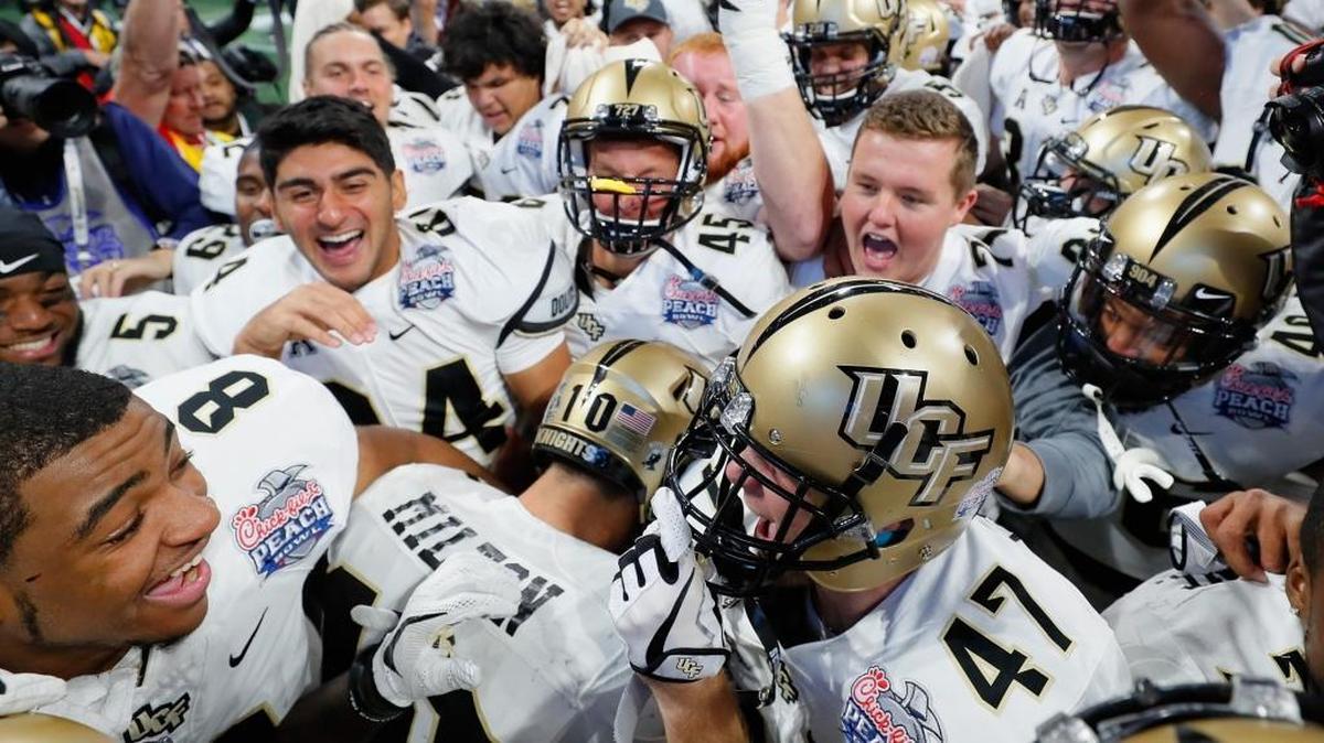 The UCF Knights celebrate defeating the Auburn Tigers 34-27 to win the Chick-fil-A Peach Bowl at Mercedes-Benz Stadium on Jan. 1, 2018, in Atlanta, Georgia.