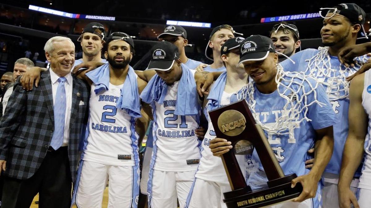 North Carolina head coach Roy Williams, left, celebrates with his players after they beat Kentucky 75-73 in the South Regional final game in the NCAA college basketball tournament Sunday, March 26, 2017, in Memphis, Tenn.