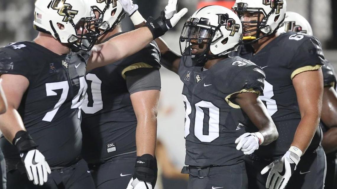 UCF players celebrate with running back Greg McCrae after he scored against FIU on Aug. 31, 2017.