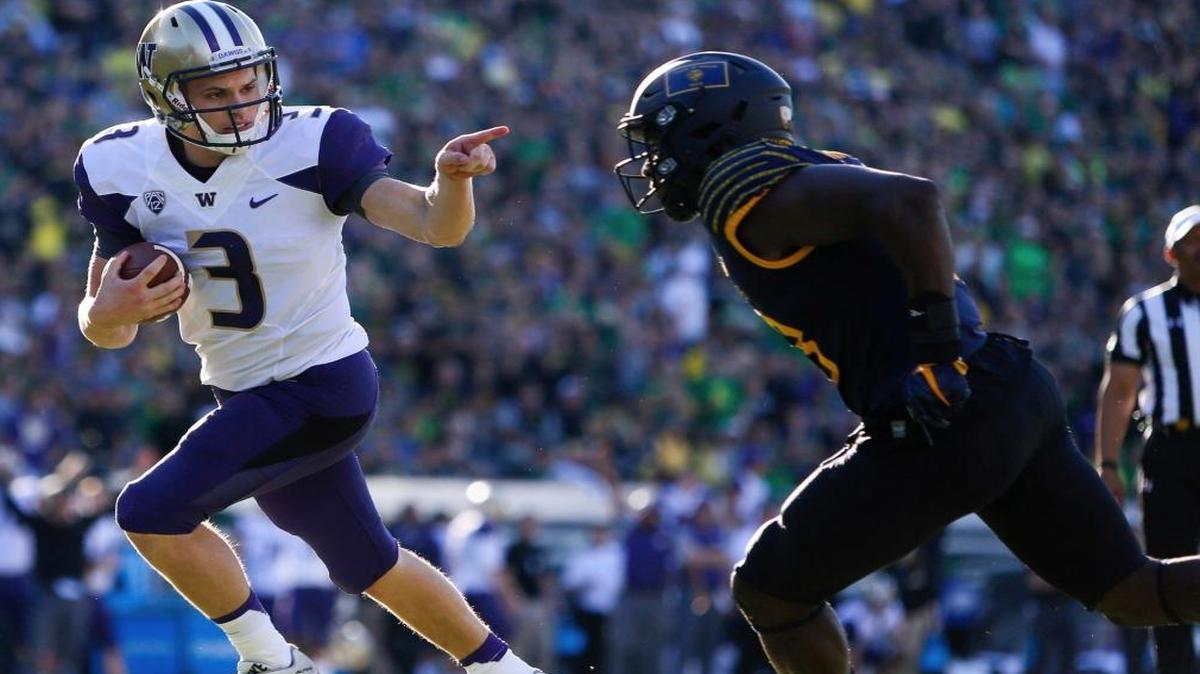 Washington quarterback Jake Browning (3) points to Oregon's Jimmie Swain (18) while rushing for a touchdown in the first quarter of an NCAA college football game in Eugene, Ore. It was so out of character it became the defining moment of his time at Washington. Maybe that's because the most exuberance Jake Browning had ever shown before was a fist pump and a smile. Then came "The Point ."