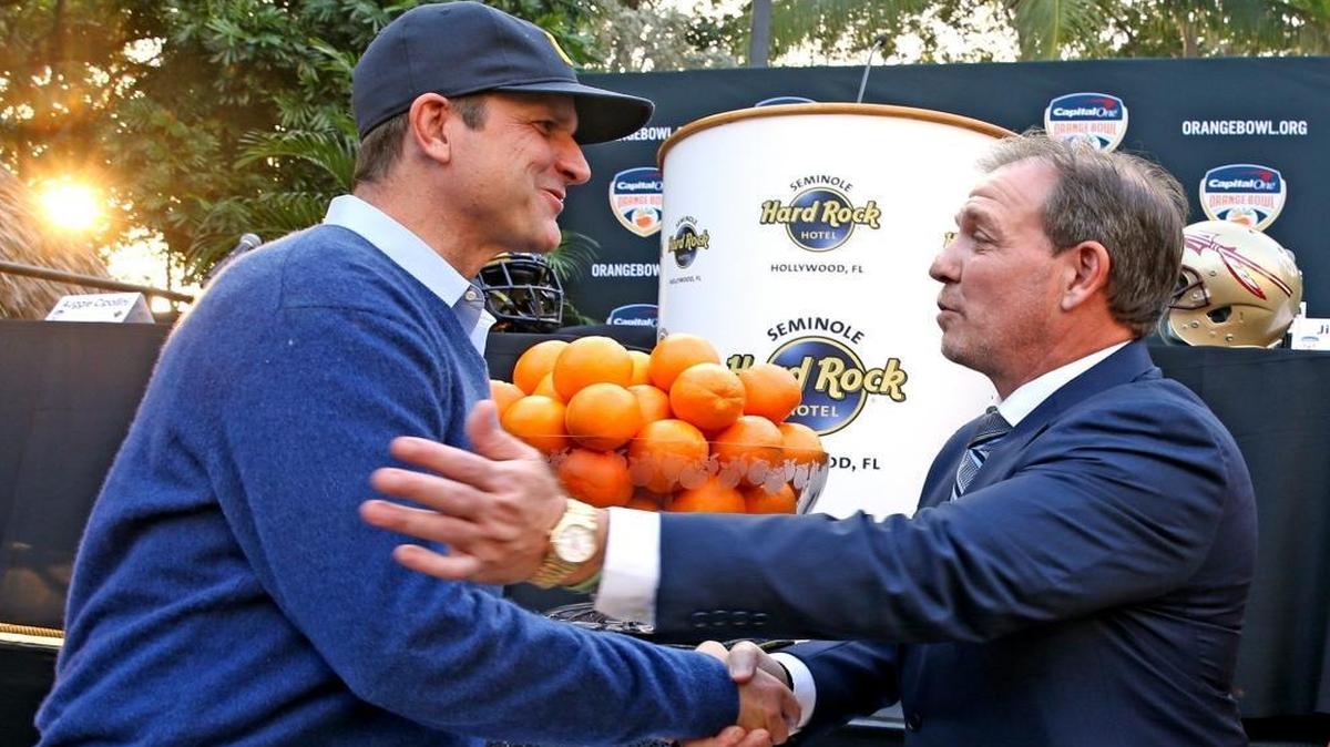 2016 Capital One Orange Bowl head coaches, Michigan’s Jim Harbaugh and Florida State’s Jimbo Fisher shake hands after a press conference at the Hard Rock Casino on Wed., Dec. 7, 2016..