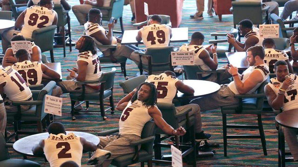 
Members of the Mississippi State football team make the best of the idle time between interviews during the Orange Bowl media day on Monday at Sun Life Stadium in Miami Gardens.
