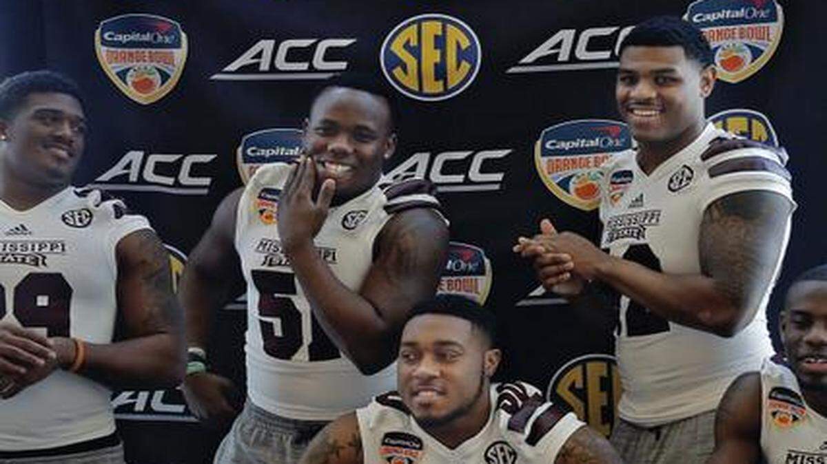 
Group effort: Teammates surround Mississippi State linebacker Benardrick McKinney after being interviewed at his booth during Orange Bowl media day on Monday. 
