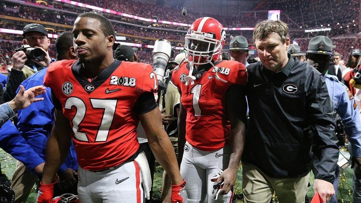 From left, Georgia’s Nick Chubb, Sony Michel and coach Kirby Smart walk off the field as Georgia loses to Alabama in the NCAA college football playoff championship game in Atlanta on Monday, Jan. 8, 2018. Alabama won, 26-23.