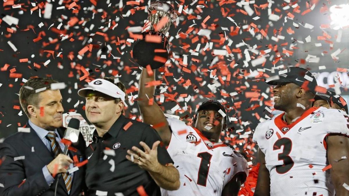 Georgia Bulldogs running back Sony Michel (1) holds the Rose Bowl trophy next to Georgia Bulldogs linebacker Roquan Smith (3) and coach Kirby Smart after the College Football Playoff Semifinal at the Rose Bowl Game on Monday, Jan. 1, 2018, in Pasadena, Calif. Georgia won 54-48 in double overtime.
