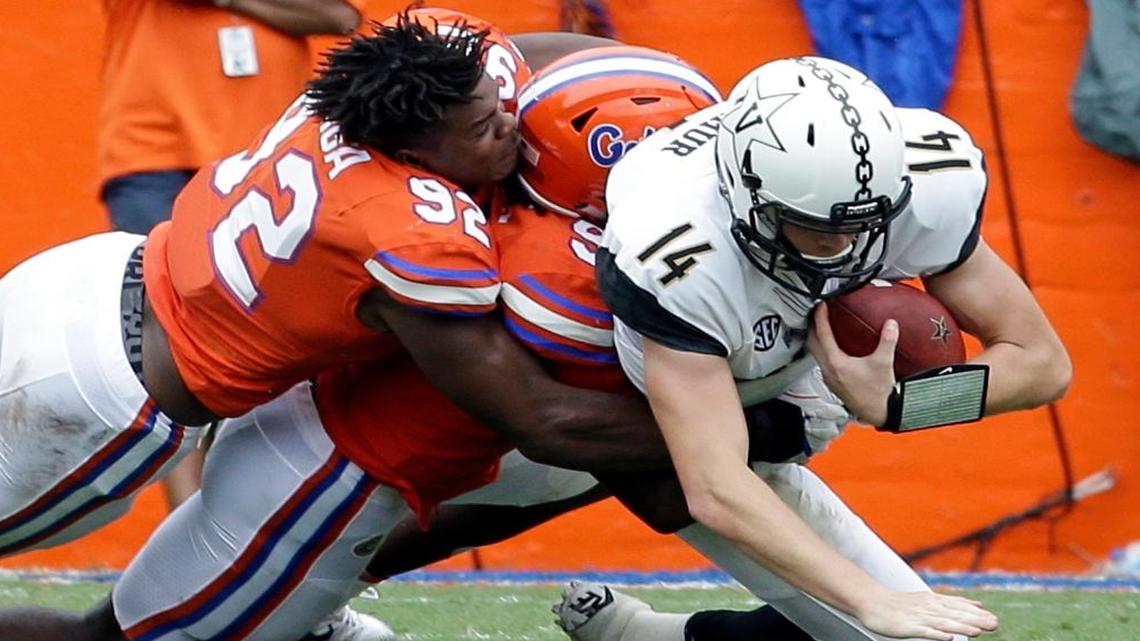Vanderbilt quarterback Kyle Shurmur (14) is sacked by Florida defensive lineman Jabari Zuniga, left, and defensive lineman Jachai Polite during the first half of an NCAA college football game in Gainesville, Fla. Vanderbilt coach Derek Mason challenging his offensive line to play better hasn't helped the Commodores run the ball better, and now they host No. 5 Georgia.