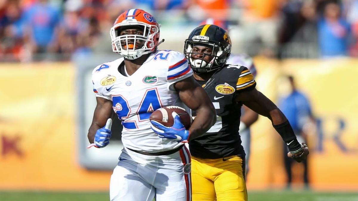 Florida Gators running back Mark Thompson (24) runs past Iowa Hawkeyes defensive back Joshua Jackson (15) on his way to score the Gators' first touchdown of the game in the second quarter during the Outback Bowl on Monday, Jan. 2, 2017 at Raymond James Stadium in Tampa, Fla.