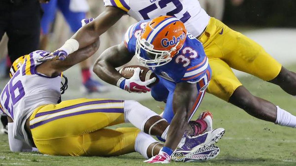 
Florida running back Mack Brown (33) pounds for extra yardage as he collides with Louisiana State safety Ronald Martin (26) and linebacker Kendell Beckwith (52) at Ben Hill Griffin Stadium in Gainesville on Oct. 11, 2014.

