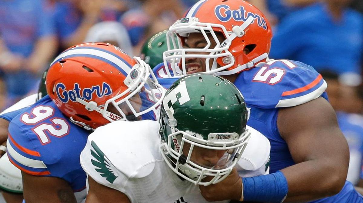 
Eastern Michigan running back Darius Jackson is stopped by Florida's defensive lineman Gerald Willis (92) and defensive lineman Caleb Brantley (57) on Saturday, Sept. 6, 2014 in Gainesville. 
