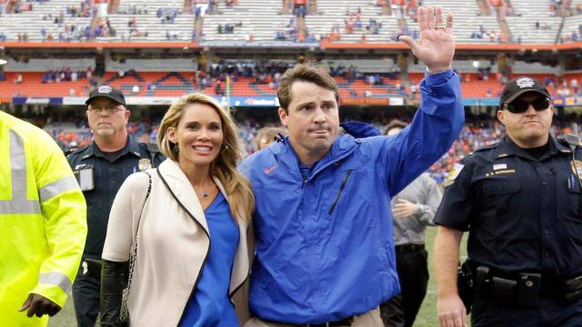 
Final goodbye: UF coach Will Muschamp waves to fans as he leaves the field with his wife Carol after coaching his final game in Gainesville.
