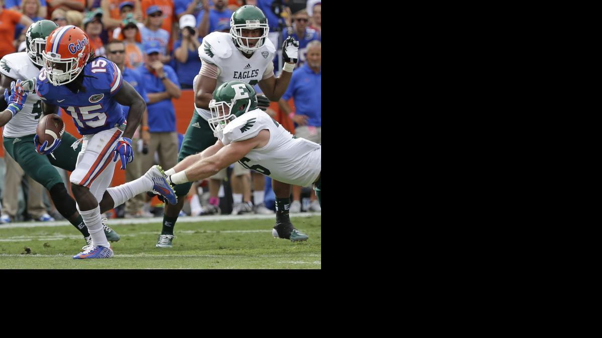 
Florida running back Brandon Powell (15) gets past Eastern Michigan linebacker Nathan Adams, right, on his way to a 12-yard touchdown run during the first half of an NCAA college football game in Gainesville, Fla., Saturday, Sept. 6, 2014. 

