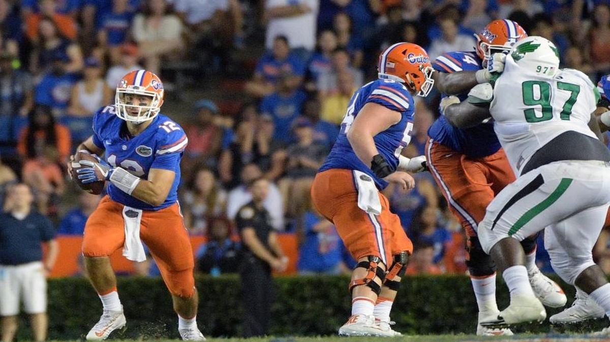 Florida quarterback Austin Appleby (12) scrambles for yardage past North Texas defensive tackle Demonte Hood (97) during the second half of an NCAA college football game in Gainesville, Fla., Sat., Sept. 17, 2016.