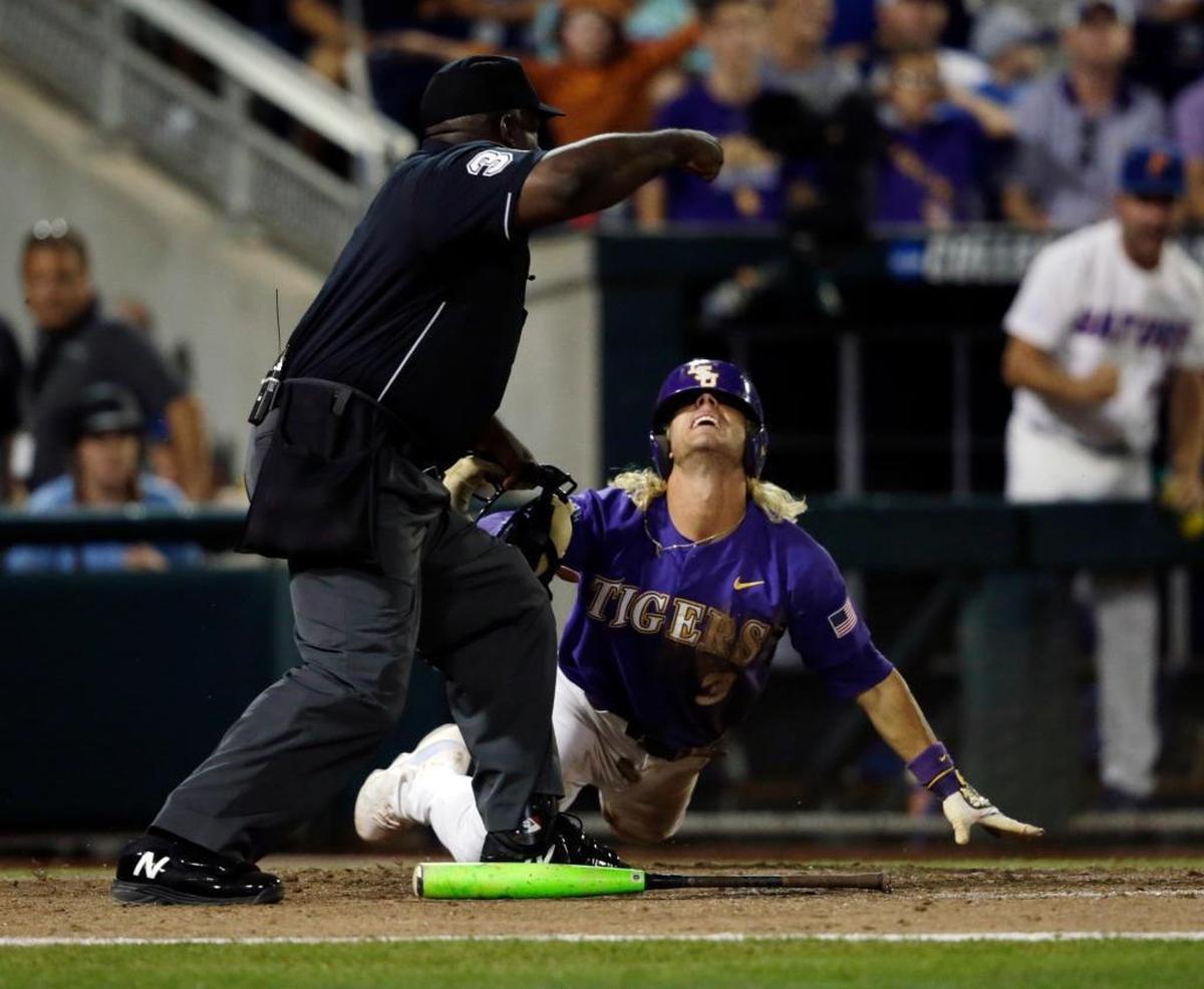 LSU's Kramer Robertson, right, reacts after being called out at home plate by umpire Troy Fullwood in the eighth inning against Florida in Game 2 of the NCAA College World Series baseball finals in Omaha, Neb., Tues., June 27, 2017.