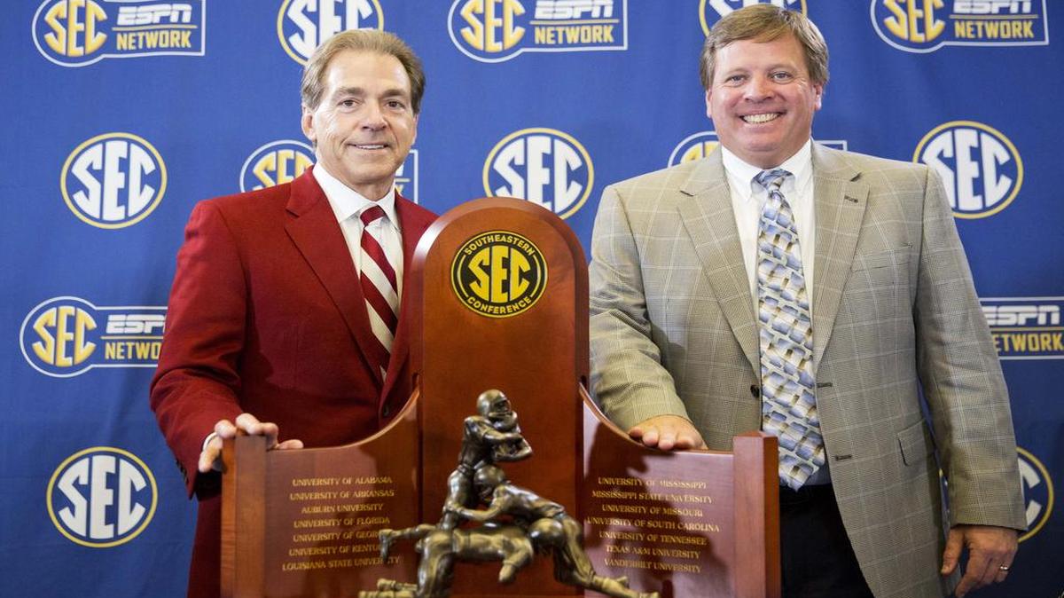 Alabama coach Nick Saban, left, and Florida coach Jim McElwain pose with the trophy during a press conference ahead of Saturday’s SEC championship game on Friday, Dec. 4, 2015, in Atlanta.