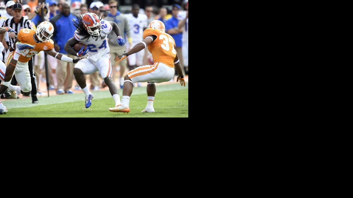 
Florida running back Matt Jones (24) evades Tennessee defensive backs Cameron Sutton (23) and Brian Randolph (37) uring the first half of an NCAA college football game at Neyland Stadium, Saturday, Oct. 4, 2014, in Knoxville, Tenn. 
