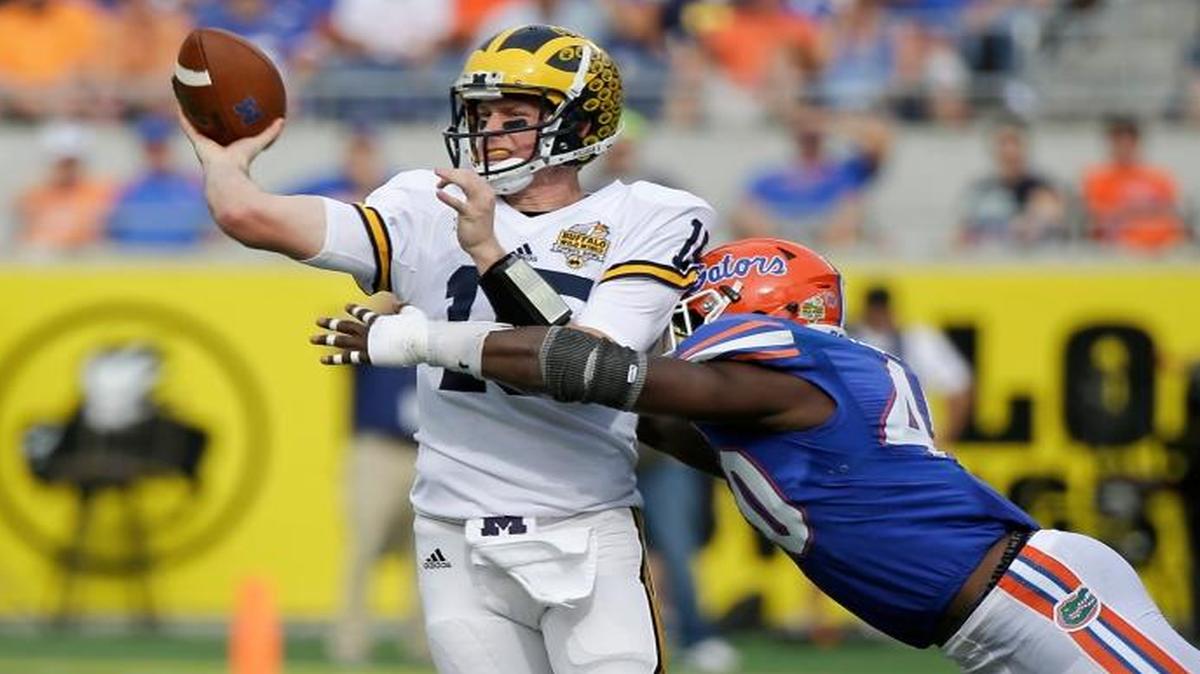 Michigan quarterback Jake Rudock, left, throws a pass as he is hit by Florida linebacker Jarrad Davis, right, during the first half of the Citrus Bowl on Friday, Jan. 1, 2016, in Orlando, Fla.