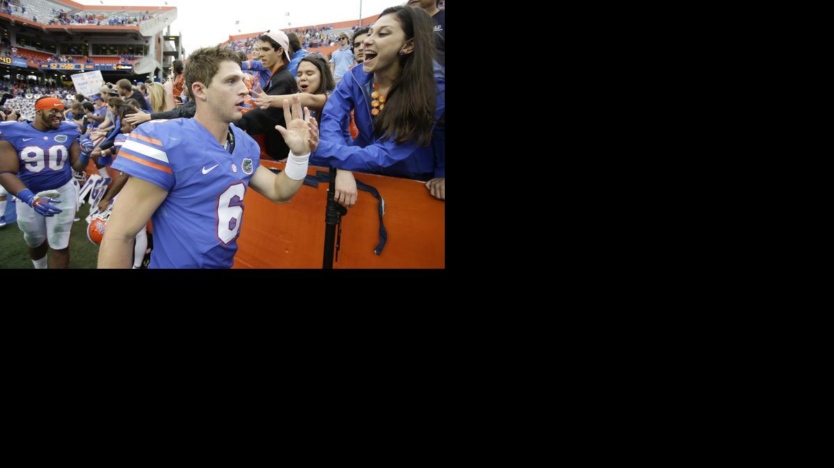 
Florida quarterback Jeff Driskel (6) and defensive lineman Jonathan Bullard (90) high five fans after an NCAA college football game against Eastern Kentucky in Gainesville, Fla., Saturday, Nov. 22, 2014. Florida won 52-3. 
