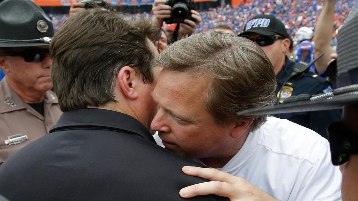 South Carolina head coach Will Muschamp, left, and Florida head coach Jim McElwain meet on the field after an NCAA college football game, Saturday, Nov. 12, 2016, in Gainesville, Fla. Florida won 20-7.