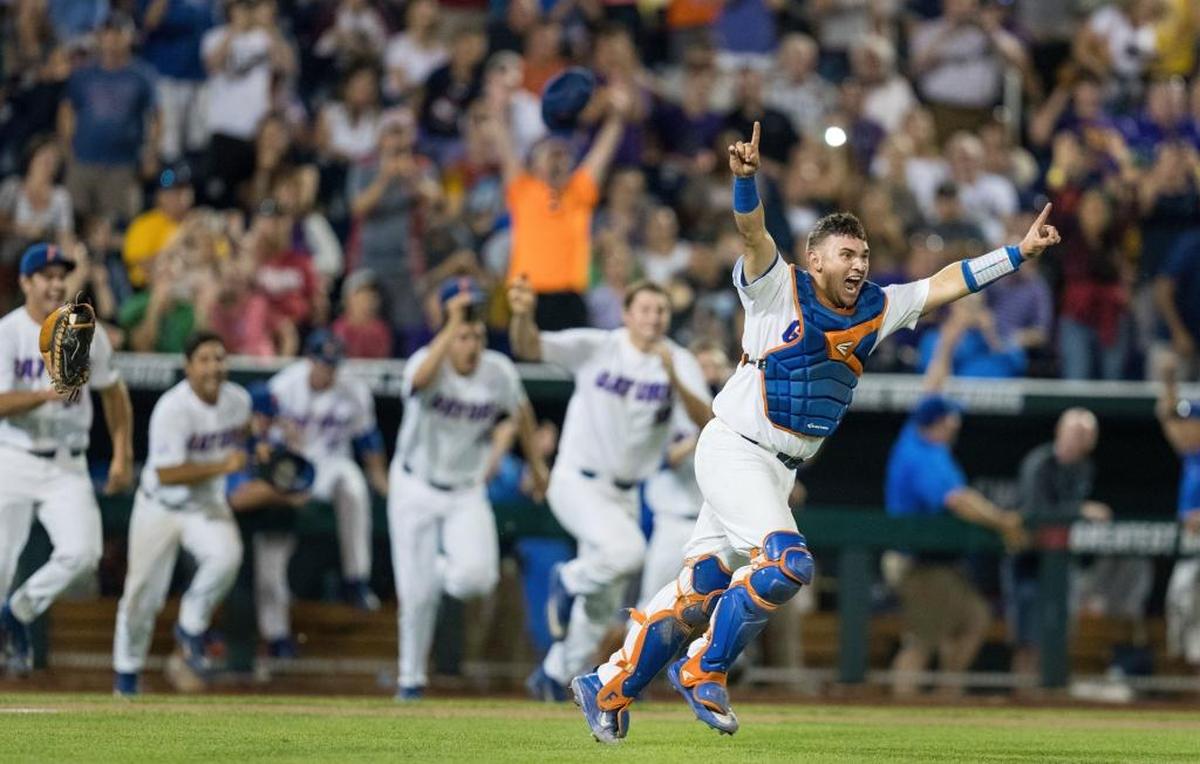 Catcher Mike Rivera (4) leads the exuberant parade of Gators out of the dugout after Florida sealed its first baseball national title on Tuesday night.