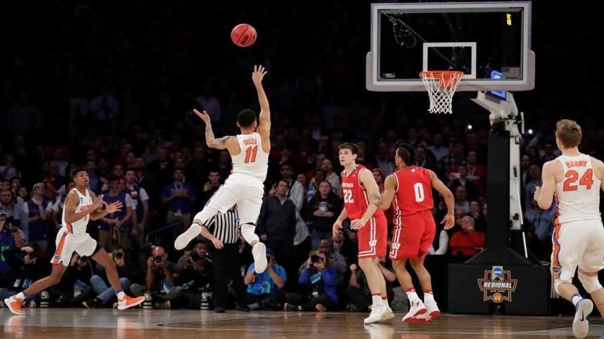 Florida guard Chris Chiozza (11) puts up a last second 3-point shot to score the game-winning points against Wisconsin in overtime of an East Regional semifinal game of the NCAA men's college basketball tournament, Sat., March 25, 2017, in New York. Florida won 84-83.