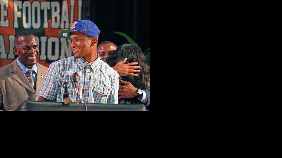 
Treon Harris signs with the University of Florida during National Signing Day at Booker T. Washington on Wednesday, Feb. 5, 2014. At left is head coach Tim Harris.
