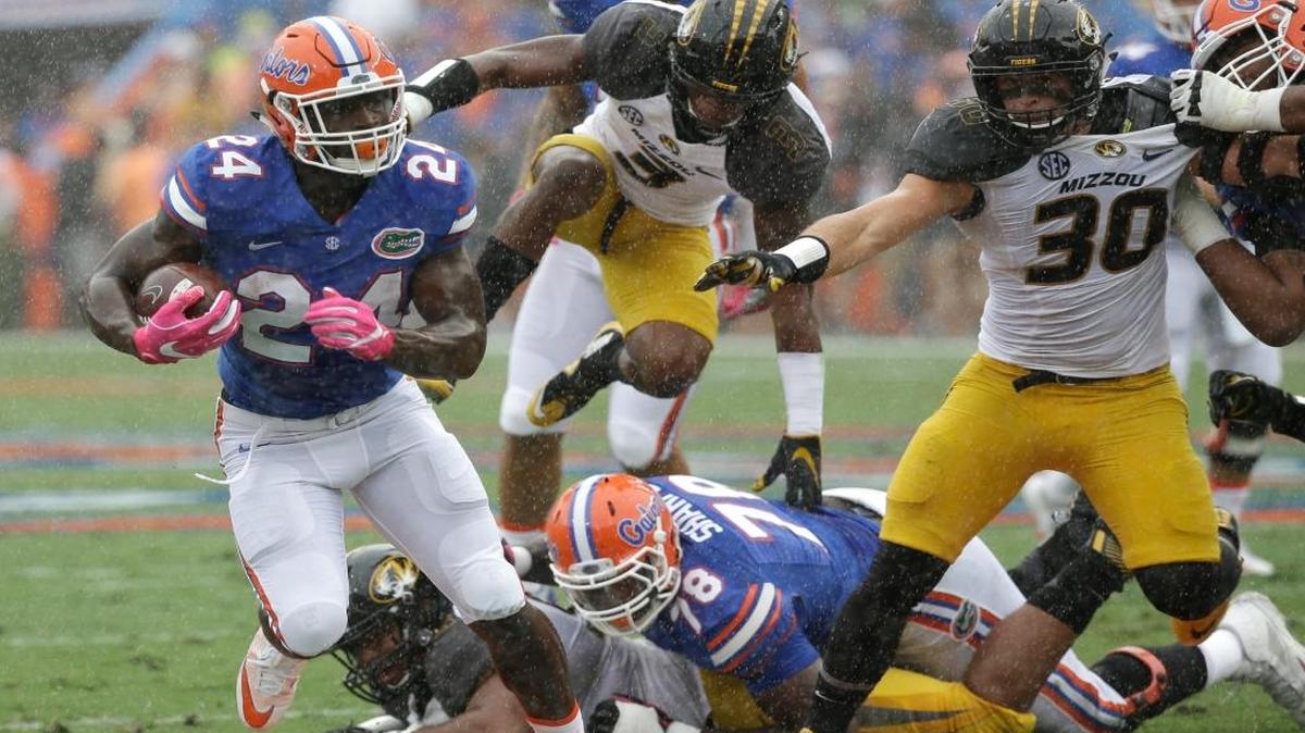 Florida running back Mark Thompson (24) runs for yardage as he gets by Missouri safety Ronnell Perkins, center, and linebacker Michael Scherer (30) during the first half of an NCAA college football game, Saturday, Oct. 15, 2016, in Gainesville, Fla.