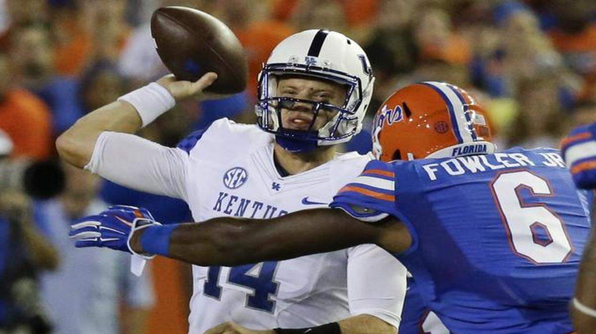 
Kentucky QB Patrick Towles gets off a pass just before he is hit by Florida defensive lineman Dante Fowler Jr. on Saturday, Sept. 13, 2014 in Gainesville. 
