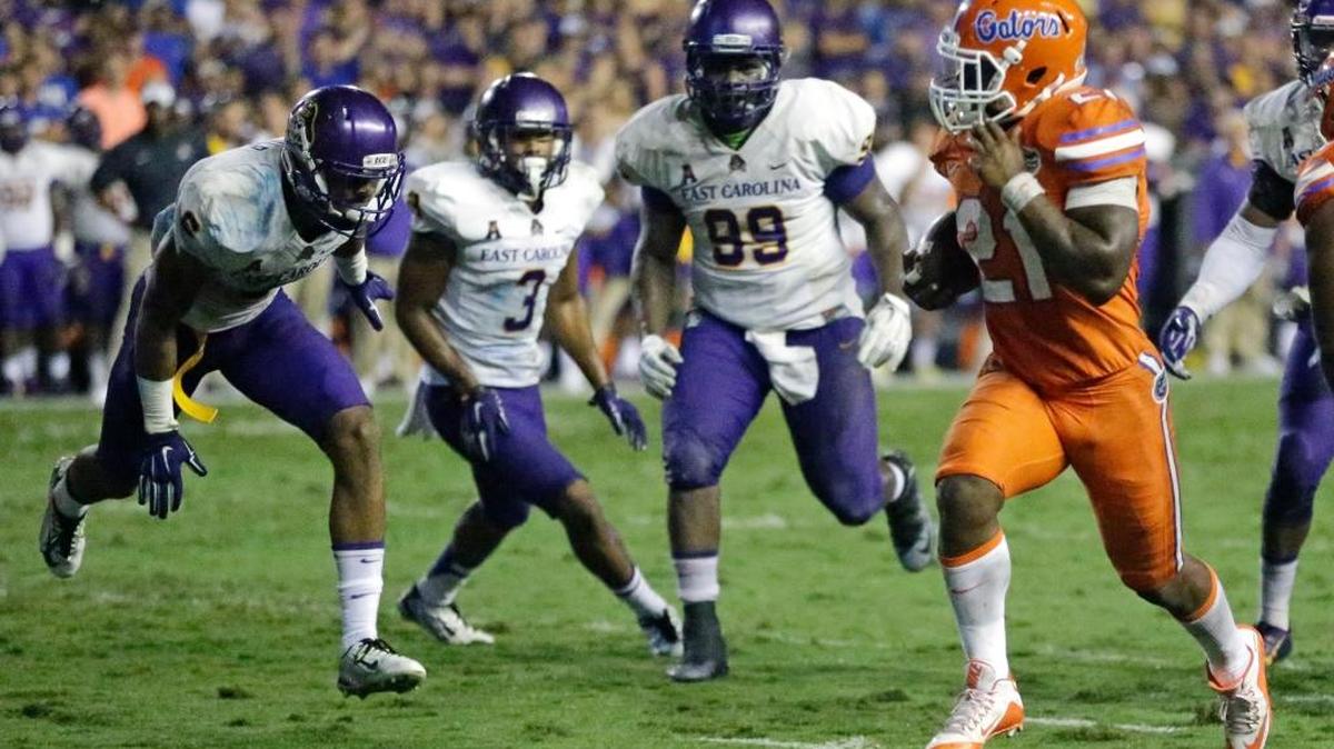
Florida running back Kelvin Taylor (21) gets past East Carolina defensive players including Fred Presley (99) and Travon Simmons (3) for a 7-yard touchdown run during the second half of an NCAA college football game, Saturday, Sept. 12, 2015, in Gainesville, Fla. Florida won 31-24.
