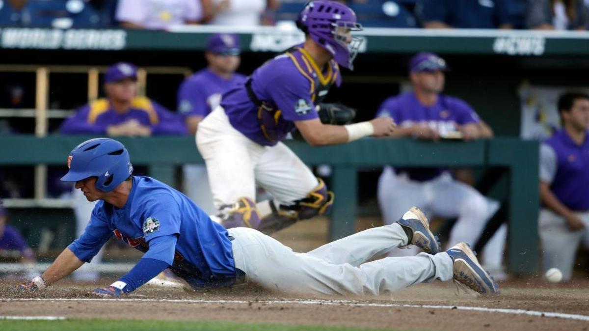 Florida's Dalton Guthrie, left, scores on a ground rule double in the fourth inning of Game 1 of the NCAA College World Series baseball finals against LSU in Omaha, Neb., Mon., June 26, 2017.