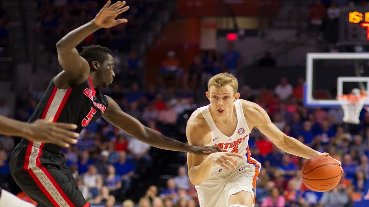 Florida guard Canyon Barry (24) dribbles past Georgia forward Pape Diatta (5) during the first half of an NCAA college basketball game in Gainesville, Fla., Sat., Jan. 14, 2017.