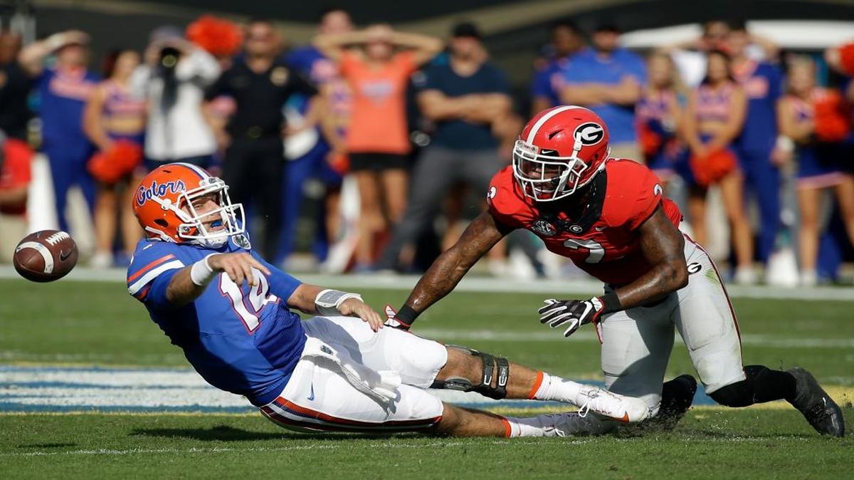 Florida quarterback Luke Del Rio, left, tries to pass the ball before being sacked by Georgia defensive back Maurice Smith during the first half of an NCAA college football game, Sat., Oct. 29, 2016, in Jacksonville, Fla. Del Rio was ruled down on the play.